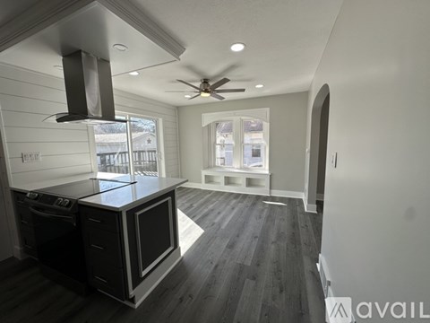 A modern kitchen with a black oven and a ceiling fan.