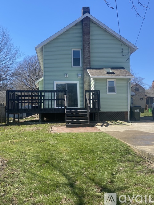 A small house with a porch and a black gate.