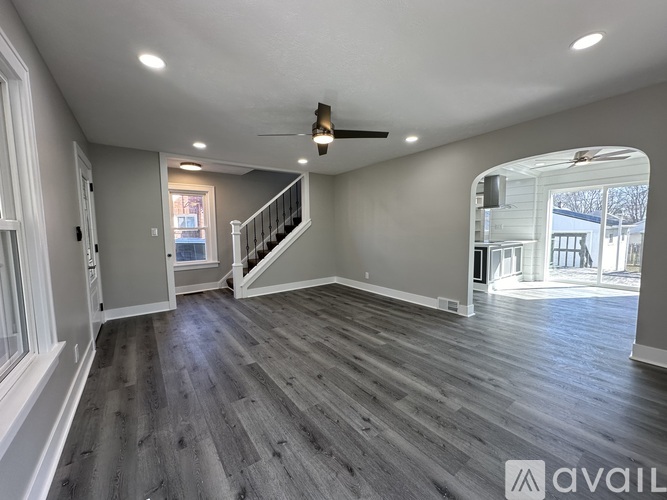 A spacious room with a staircase leading to the upper floor.