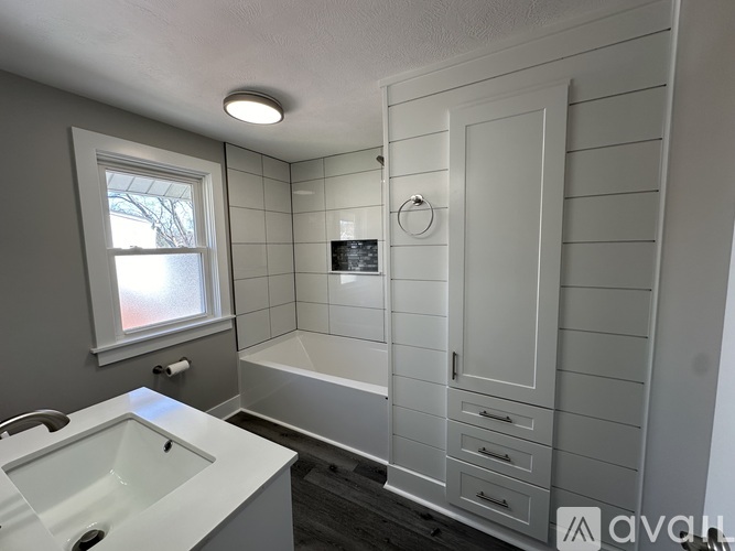 A bathroom with a white sink and a white bathtub.