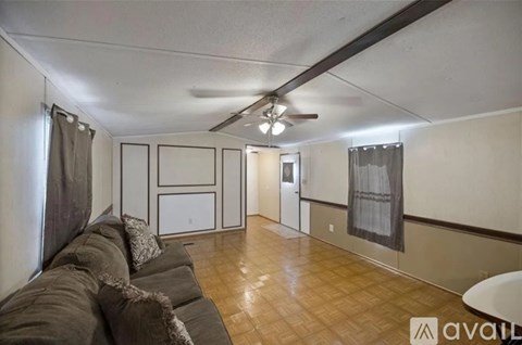 A living room with a couch and a ceiling fan.