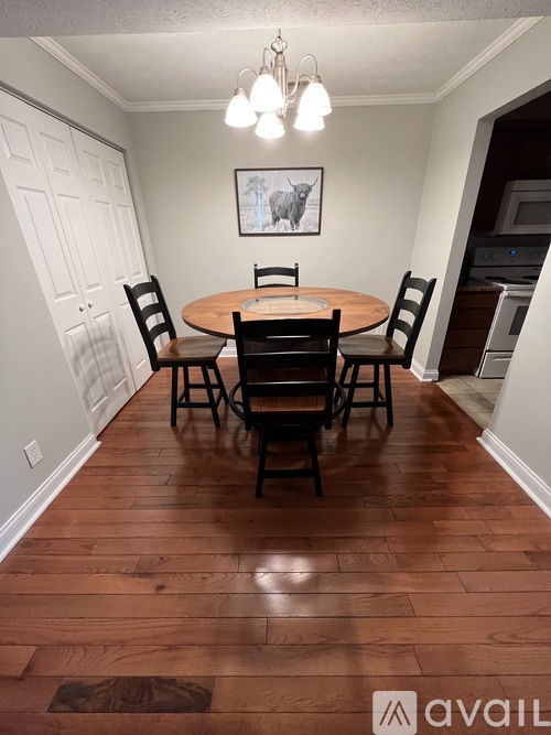 A dining room with a wooden table and chairs.