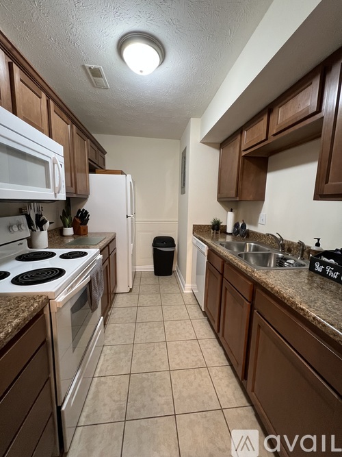 A kitchen with brown cabinets and a white stove top oven.