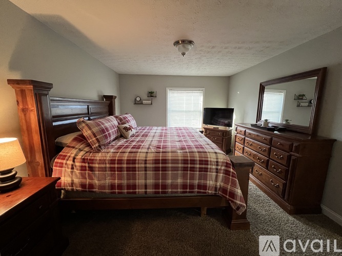 A bedroom with a bed, dresser, and mirror.