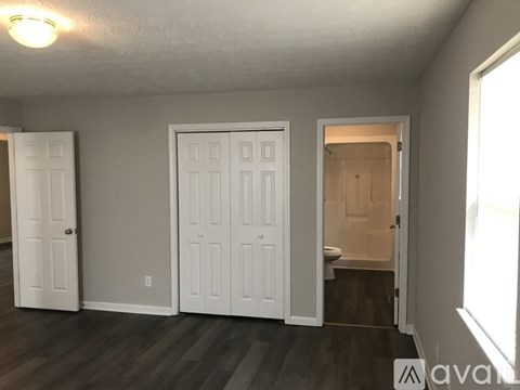 A room with a white door and a window.