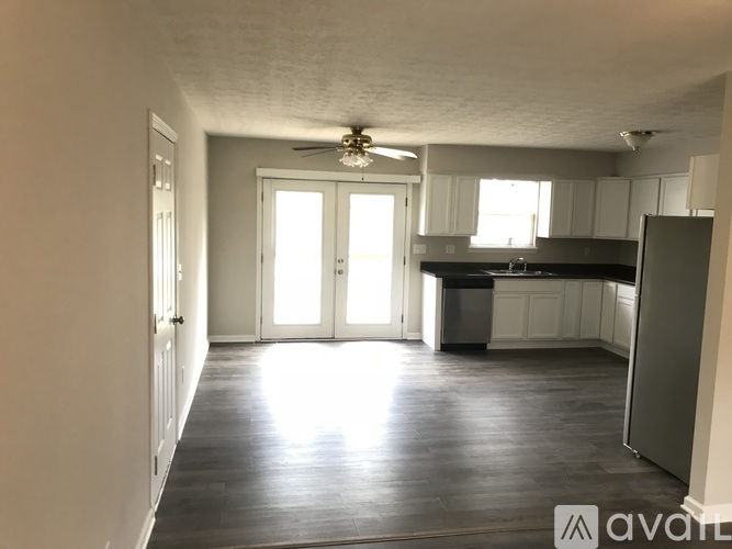 A kitchen with a refrigerator, sink, and cabinets.