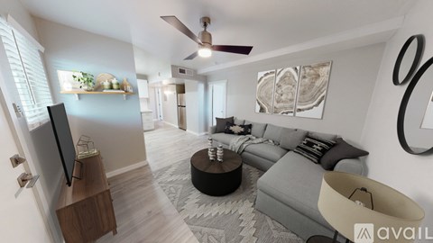 A living room with a grey couch and a television on a wooden stand.