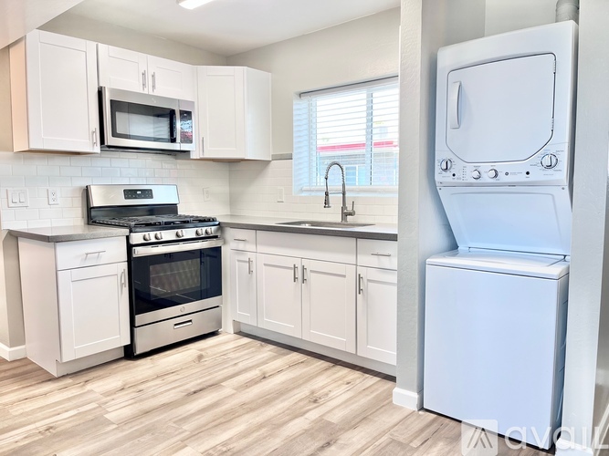 A kitchen with white appliances and cabinets.