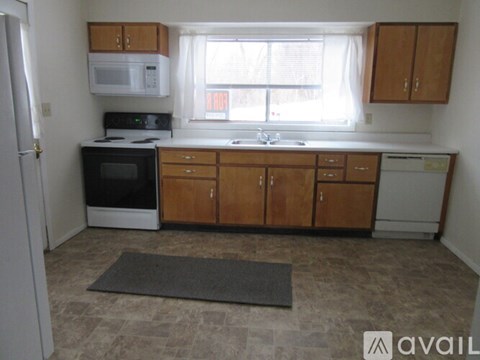 A kitchen with wooden cabinets and a black oven.