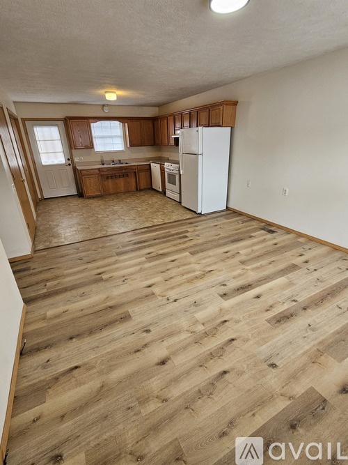 A kitchen with wooden floors and white appliances.