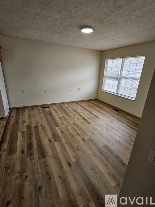 A room with wooden flooring and a window.