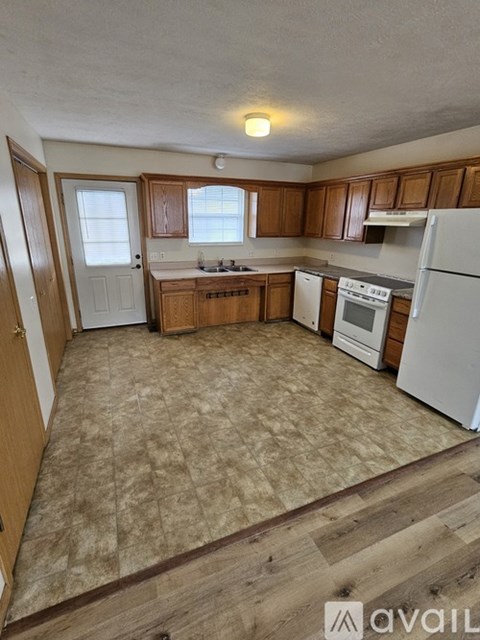 A kitchen with wooden cabinets and white appliances.
