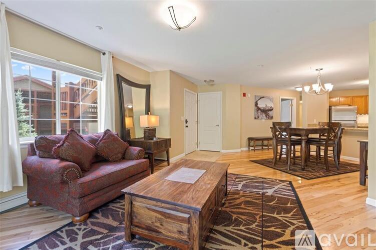 A living room with a red couch and a wooden coffee table.