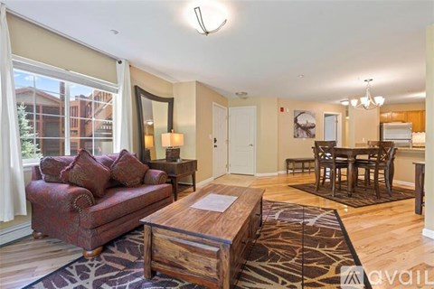 A living room with a red couch and a wooden coffee table.