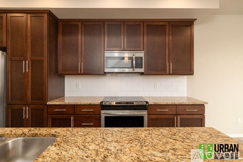 A kitchen with brown cabinets and a granite countertop.