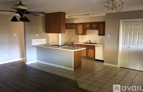 A kitchen with a white counter and brown cabinets.