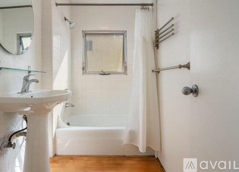 A white bathroom with a white tub and a white sink.