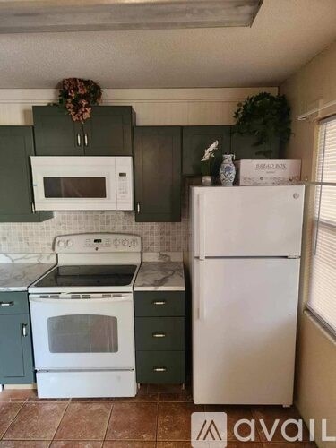 A kitchen with a white refrigerator and white stove top oven.