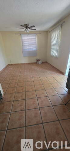 A room with a ceiling fan and tiled flooring.