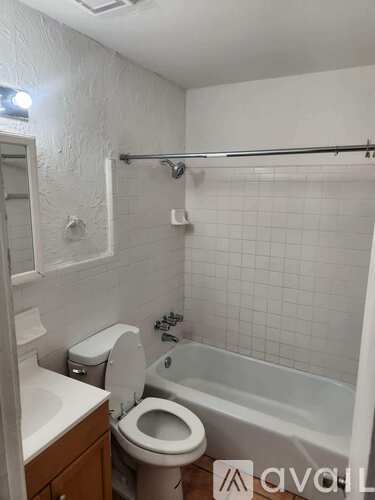 A white bathroom with a toilet, sink, and bathtub.