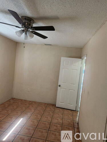 A room with a ceiling fan and a door.