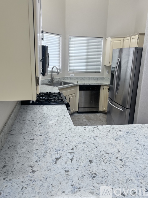 A kitchen with granite countertops and stainless steel appliances.