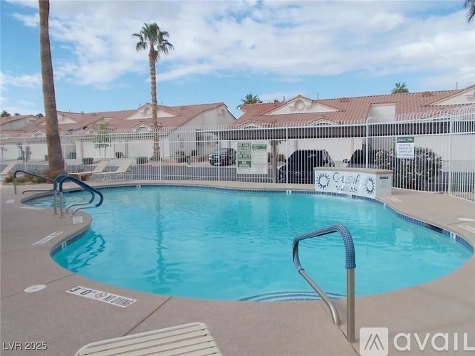 A pool with a slide and a palm tree in the background.