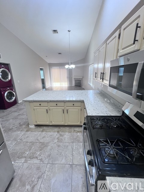 A kitchen with a stove top oven and a washing machine.