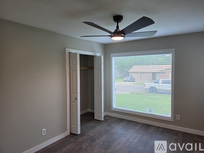A room with a ceiling fan and a sliding glass door.