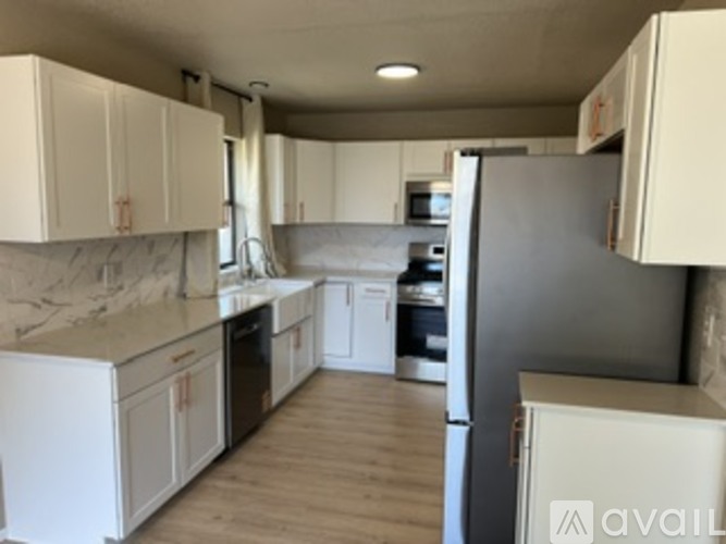 A kitchen with white cabinets and appliances.