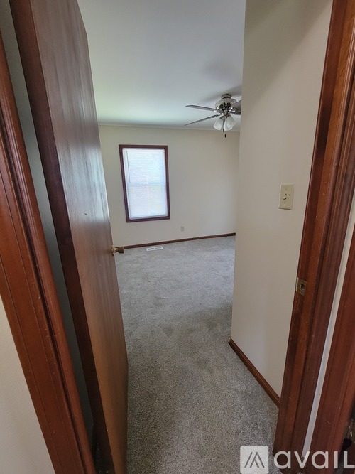 A room with a ceiling fan and a window.