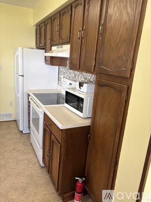 A kitchen with wooden cabinets and a white fridge.