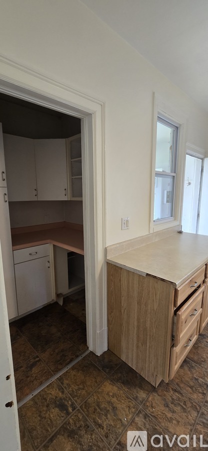 A kitchen with white cabinets and a wooden countertop.
