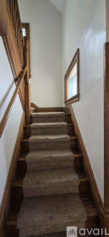 A staircase with a carpeted runner and wooden balusters.
