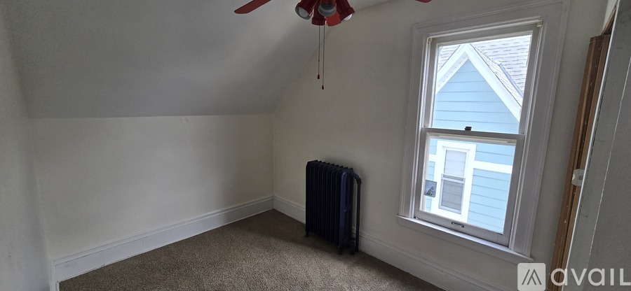 A room with a window and a fan.