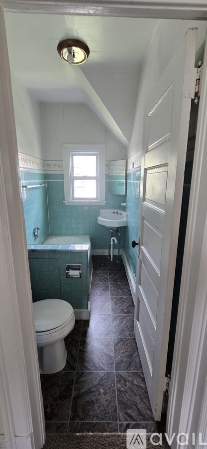 A bathroom with a toilet, sink, and bathtub.