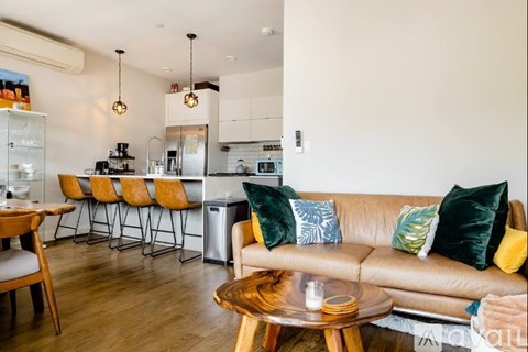 A modern living room with a brown leather couch and a wooden coffee table.
