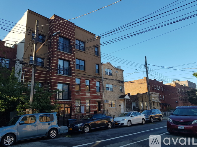 A street view of a building with cars parked in front.