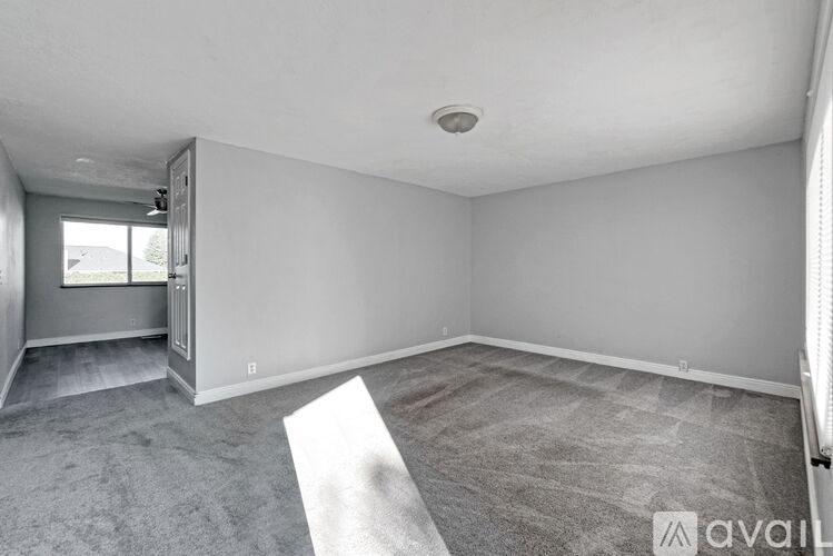 A spacious room with a carpeted floor and a window.
