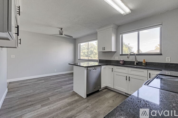 A kitchen with a stainless steel dishwasher and a window.
