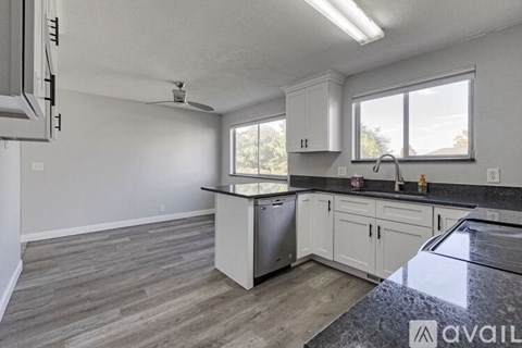 A kitchen with a stainless steel dishwasher and a window.