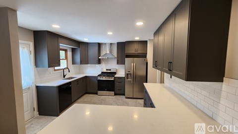 A modern kitchen with dark brown cabinets and stainless steel appliances.