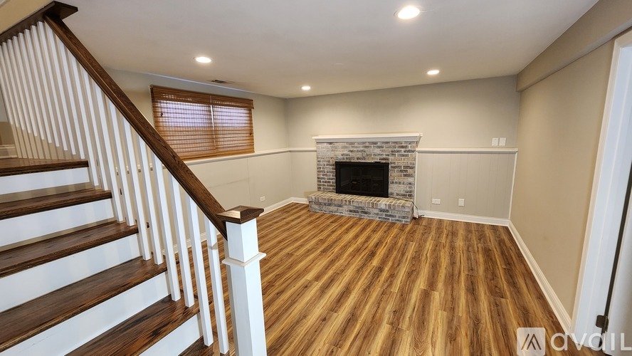 A living room with a fireplace and wooden floors.