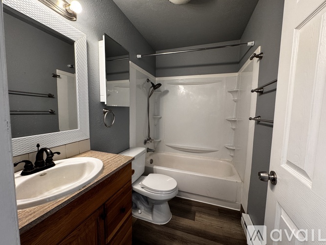 A bathroom with a white tub, sink, and toilet.