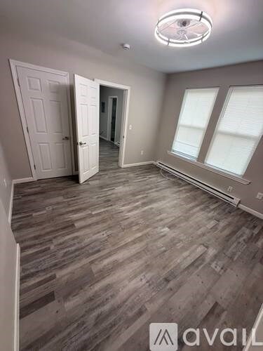 A room with wooden flooring and two doors.