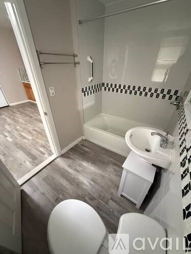 A bathroom with a toilet, sink, and shower.