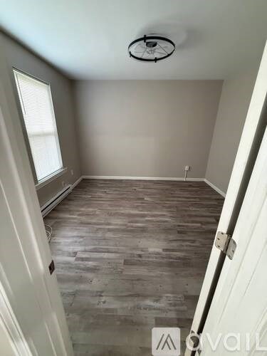 A room with wooden flooring and a white door.