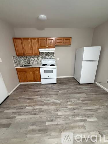 A kitchen with wooden cabinets and a white fridge.