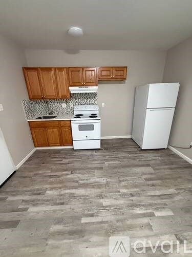 A kitchen with wooden cabinets and a white fridge.