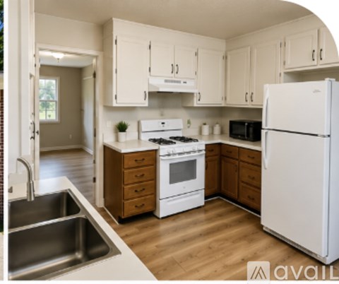 A kitchen with white appliances and wooden cabinets.